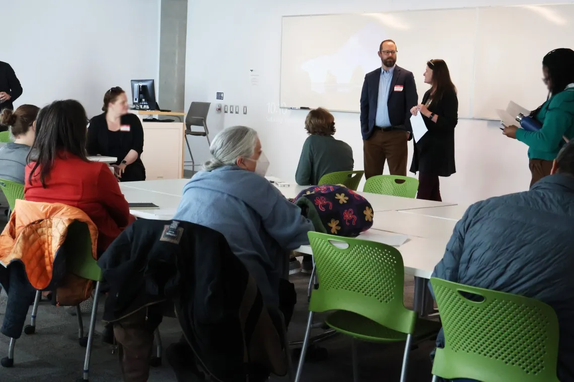 Two individuals moderate a group discussion.